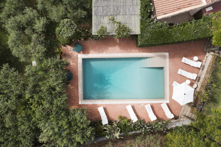 Casale Castelluzzo luxury villa in Sicily with a private pool surrounded by lush gardens.