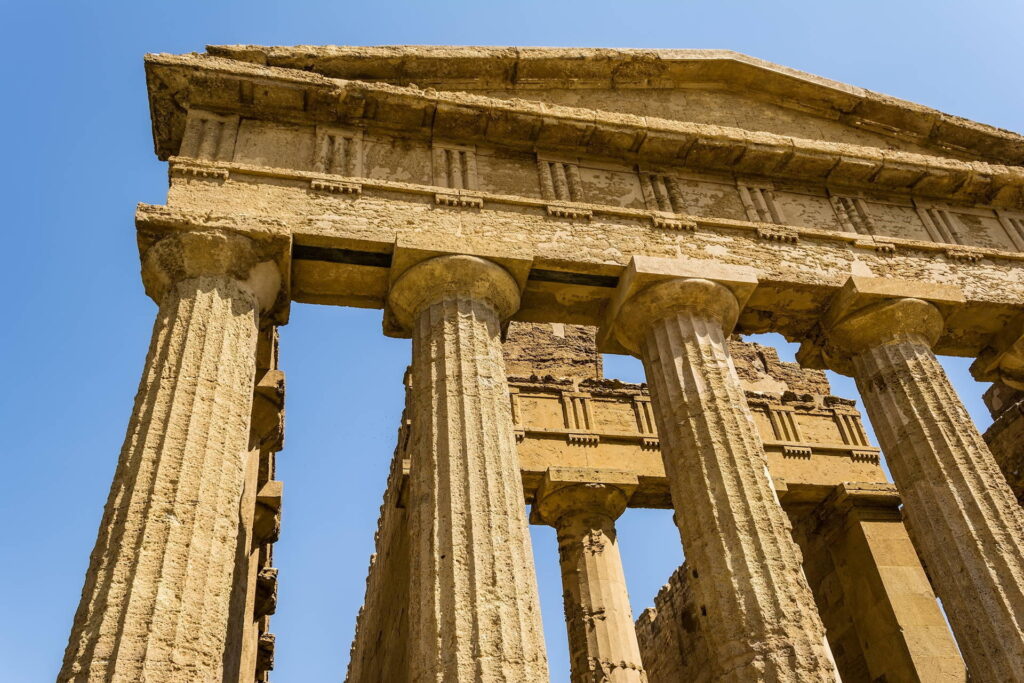 Close-up of an ancient Greek temple in the Valley of the Temples, Agrigento, Sicily, showcasing Doric columns under a clear blue sky. Sicily Holidays 2025