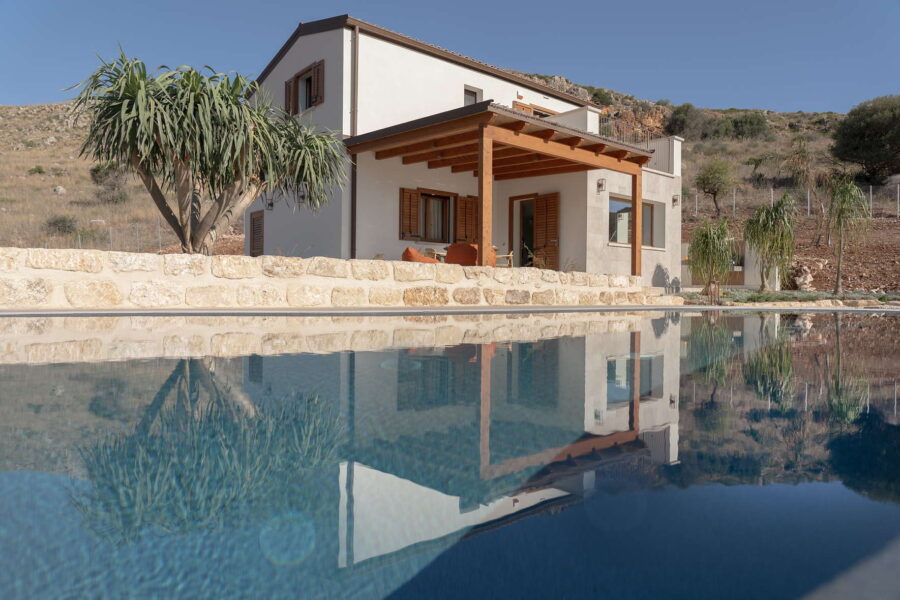 Villa Belvedere, a stunning Sicily luxury villa with pool, featuring Mediterranean architecture, a shaded patio, and hillside views.