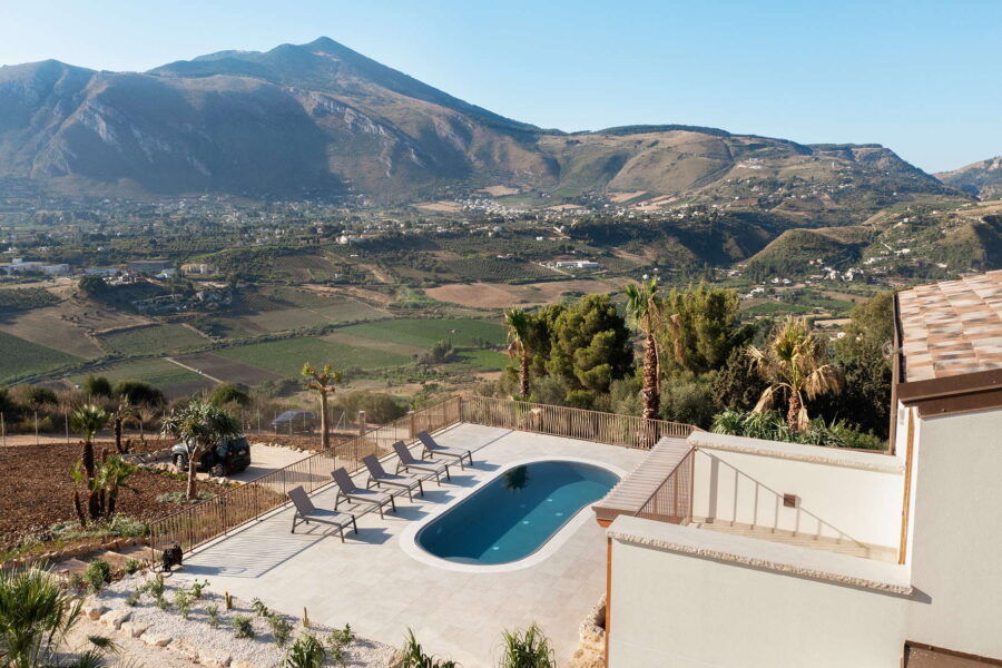 Stunning view from Villa Belvedere's pool area, overlooking the lush Sicilian countryside and surrounding mountains.