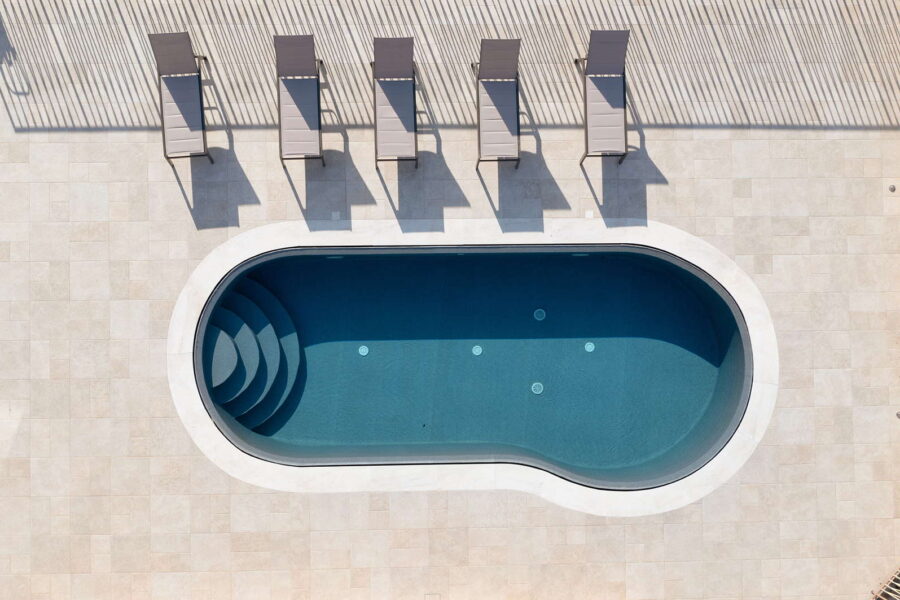 Aerial view of the stylish pool at Villa Belvedere, a Sicily luxury villa with pool, surrounded by sun loungers and a spacious sun-kissed terrace.