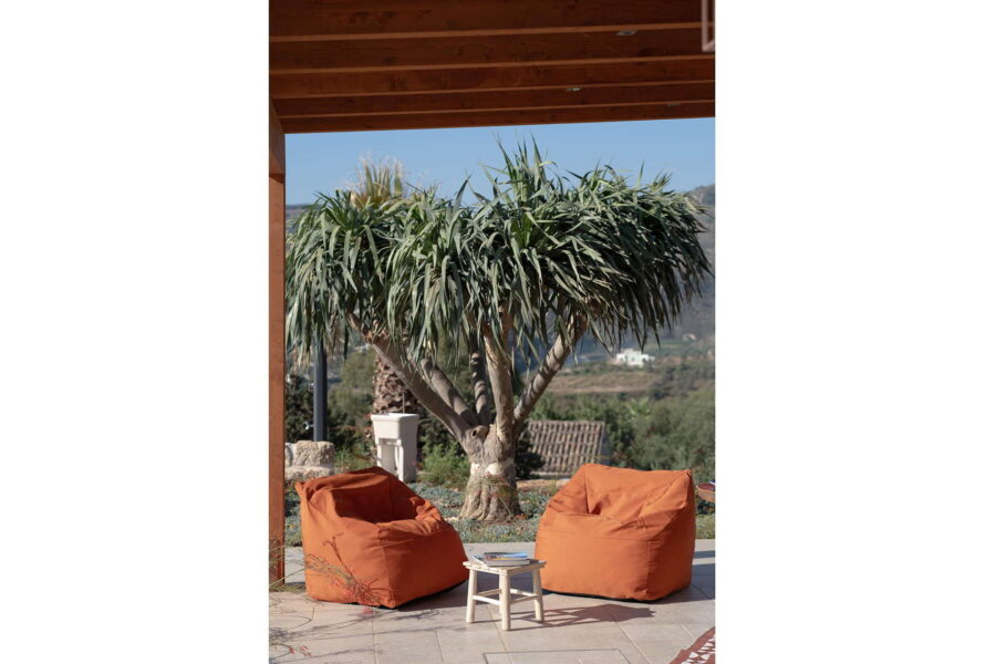 Cozy outdoor lounge at Villa Belvedere, a Sicily luxury villa with pool, featuring vibrant bean bag chairs under a shaded patio with countryside views.